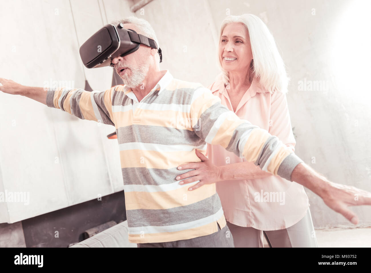 Senior interessierten Mann stehen und durch die VR Brille. Stockfoto