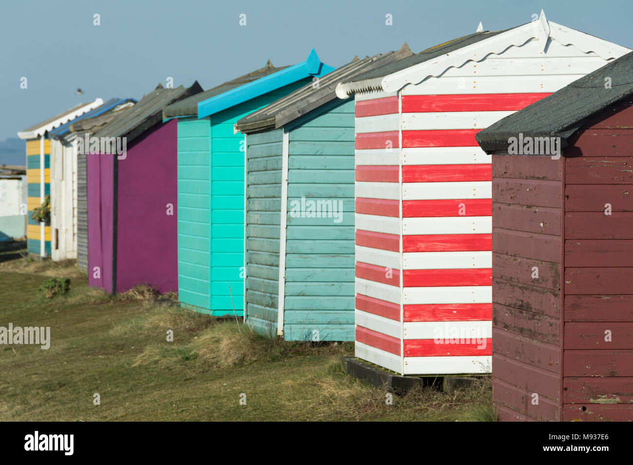 Bunte Englisch Seaside Beach Huts an der Küste in New Romney, Kent, England, Großbritannien Stockfoto
