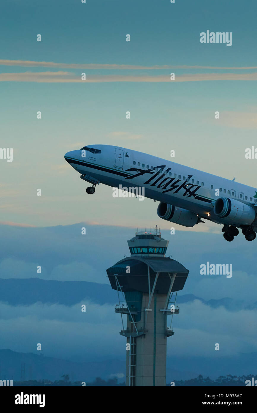 Alaska Airlines Boeing 737-900Passenger Jet vom LAX, Los Angeles International Flughafen, den Tower mit Wolken und Nebel hinter sich. Stockfoto