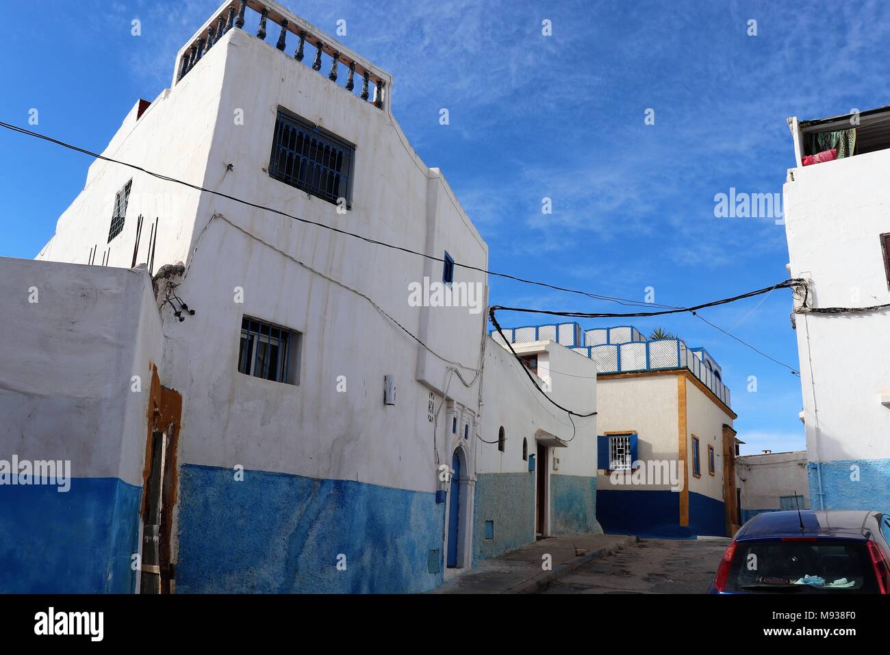 Blaue und weiße Straßen innerhalb der Kasbah des Oudayas, Rabat, Marokko mit geparkten Auto Stockfoto