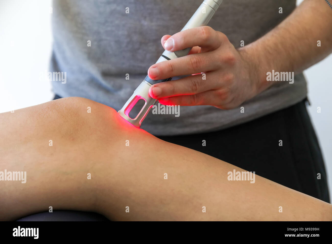 Laser Therapie auf ein Knie, angewendet zur Behandlung von Schmerzen. selektive Fokus Stockfoto
