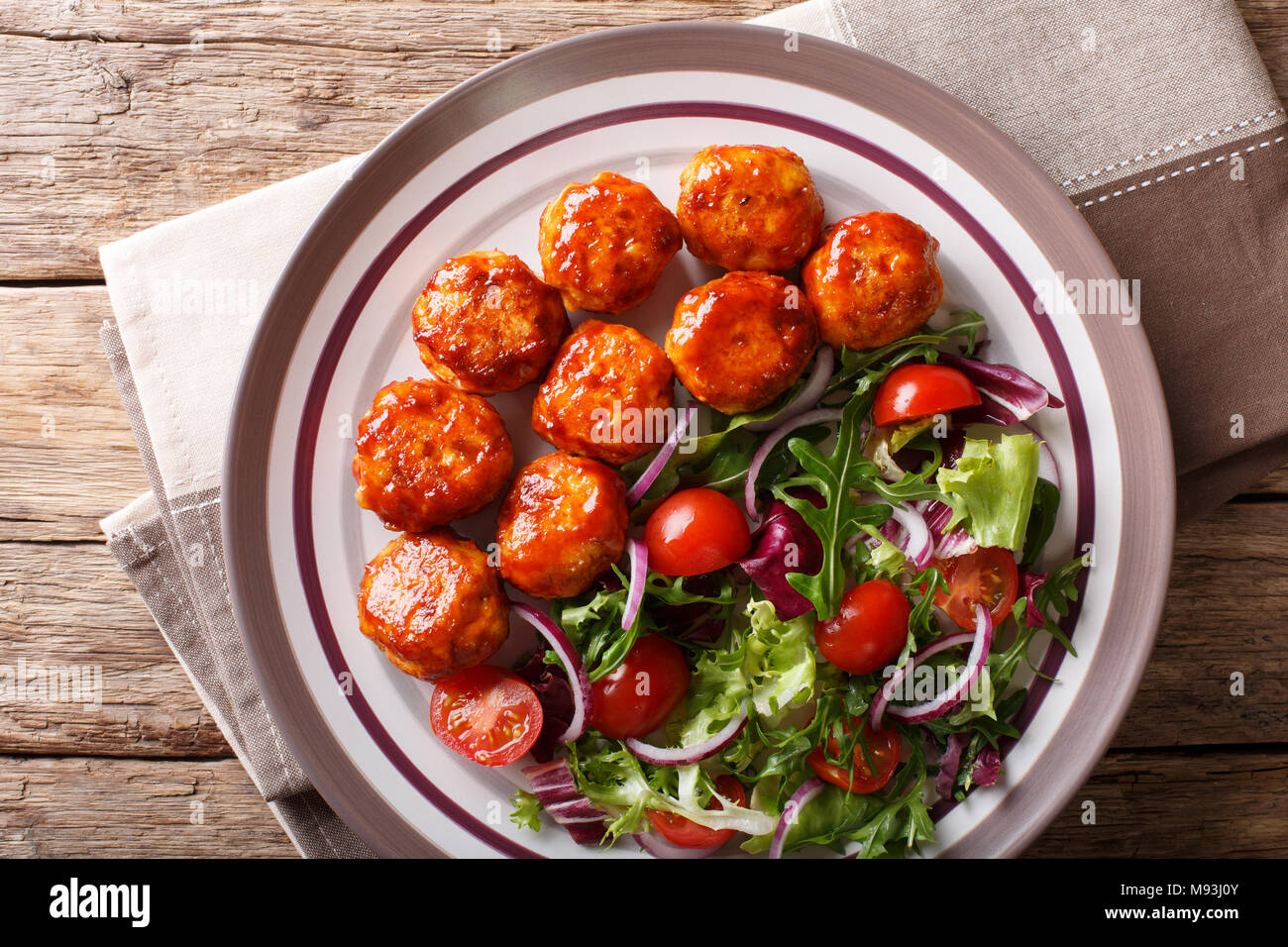 Leckeres Essen: Fried Chicken Frikadellen Salat von Tomaten, Salat und Zwiebeln close-up auf einem Teller auf den Tisch. Horizontal oben Ansicht von oben Stockfoto