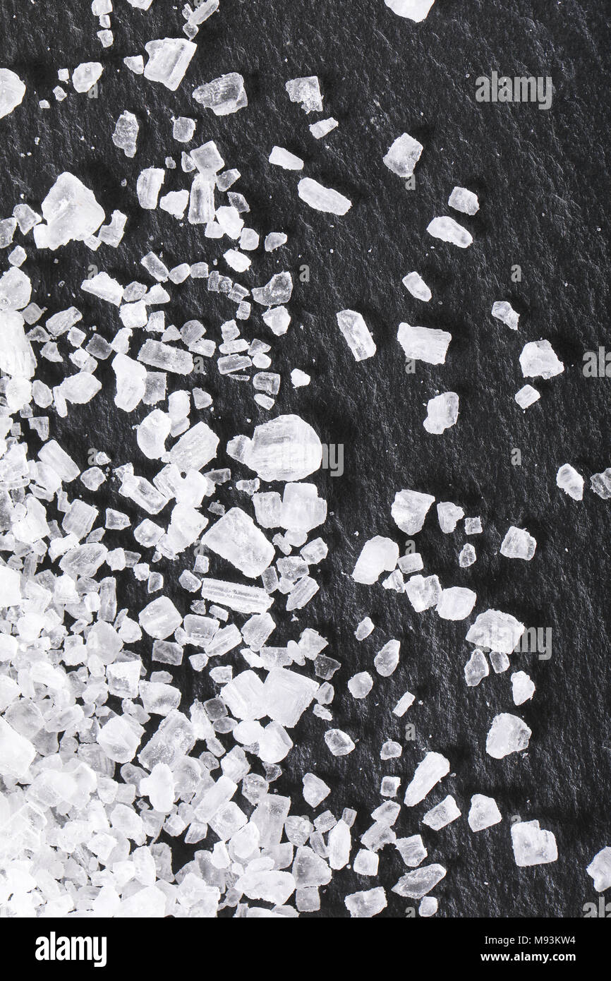Kristalle von grobkörnigem Meersalz auf schwarzem Hintergrund Stockfoto