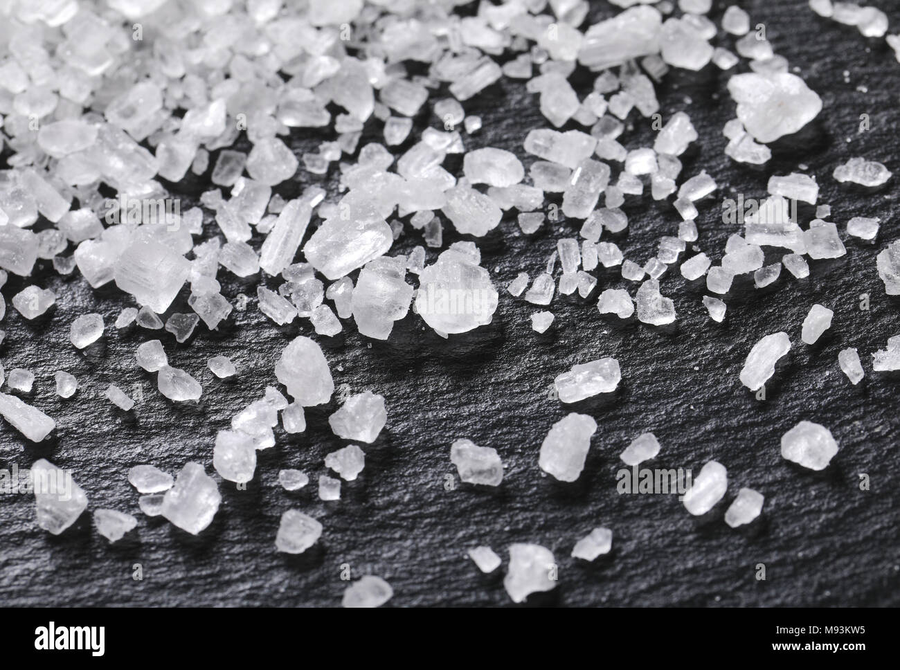 Kristalle von grobkörnigem Meersalz auf schwarzem Hintergrund - Detail Stockfoto