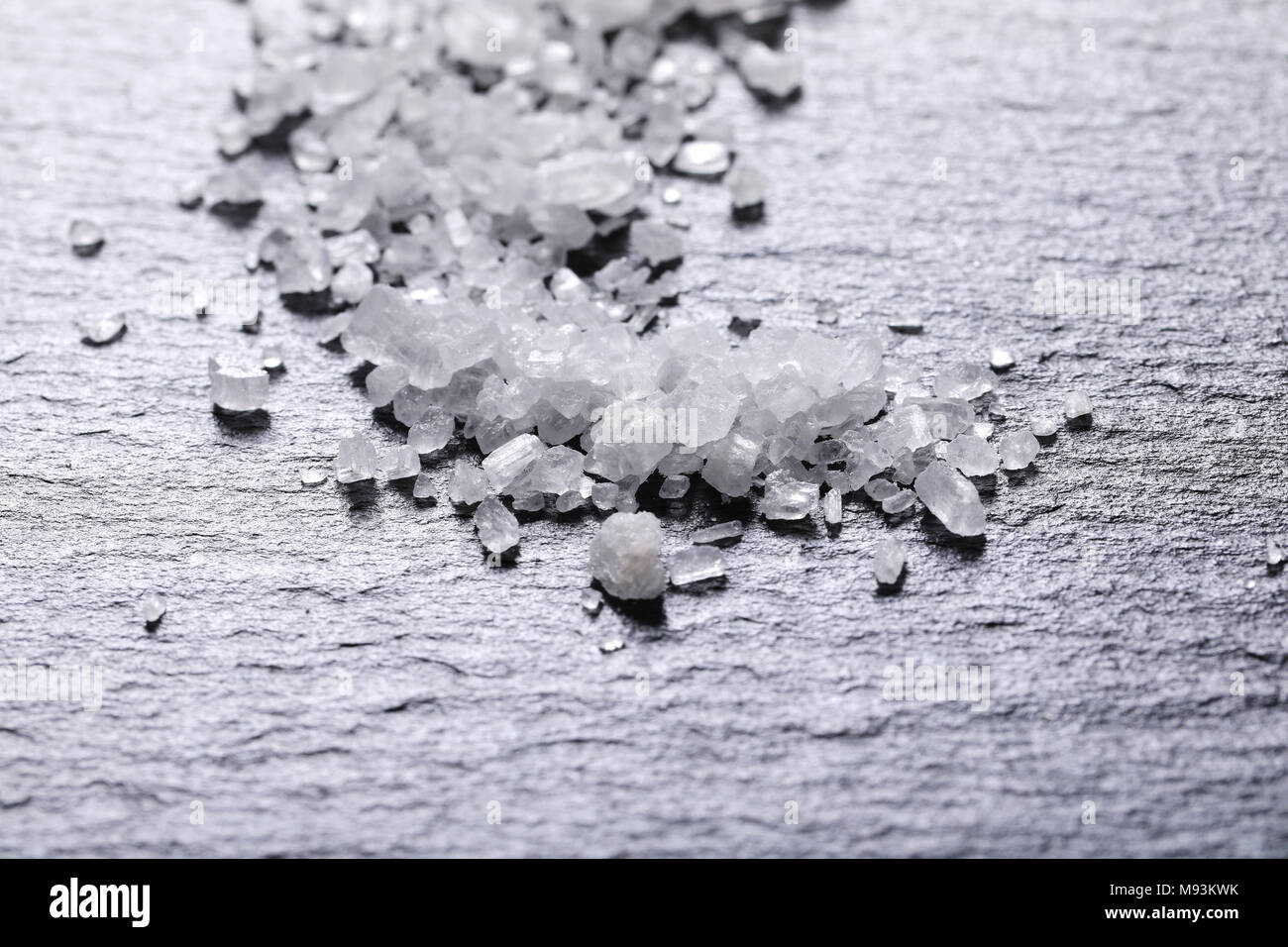 Kristalle von grobkörnigem Meersalz auf schwarzem Hintergrund - Detail Stockfoto
