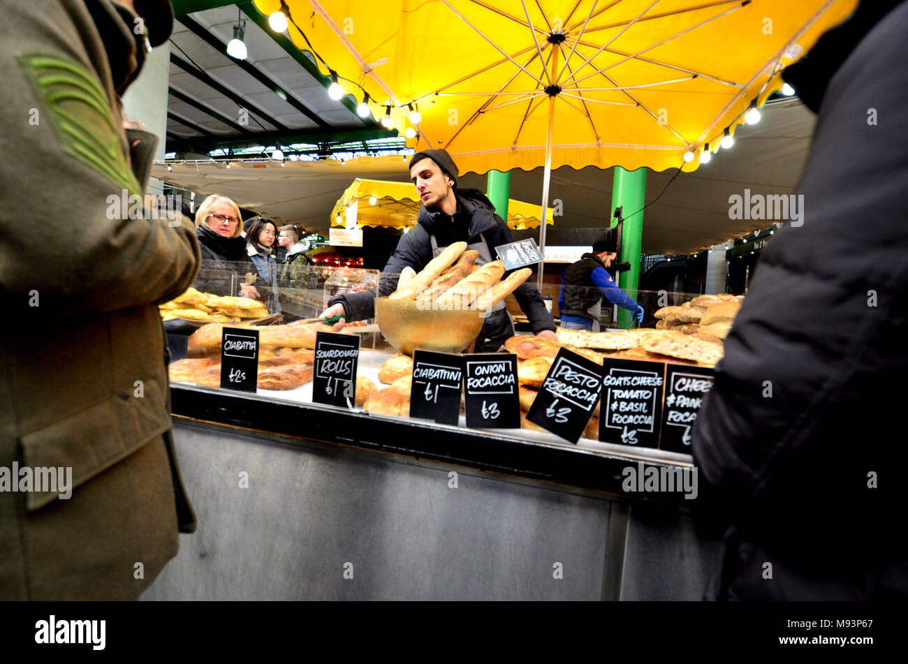 London, England, UK. Borough Market, Southwark - standbesitzer Verkauf von Brot Stockfoto
