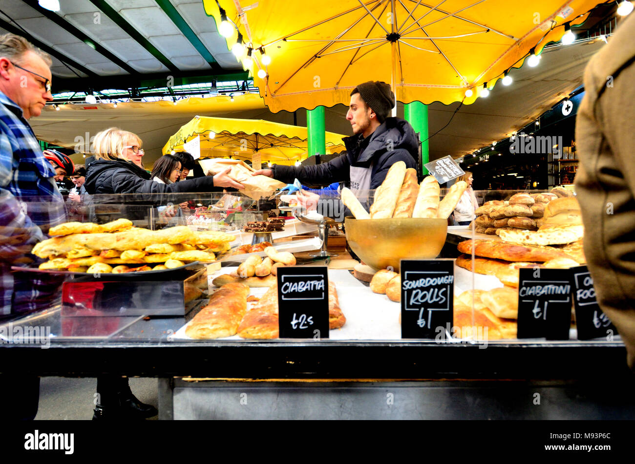 London, England, UK. Borough Market, Southwark - standbesitzer Verkauf von Brot Stockfoto