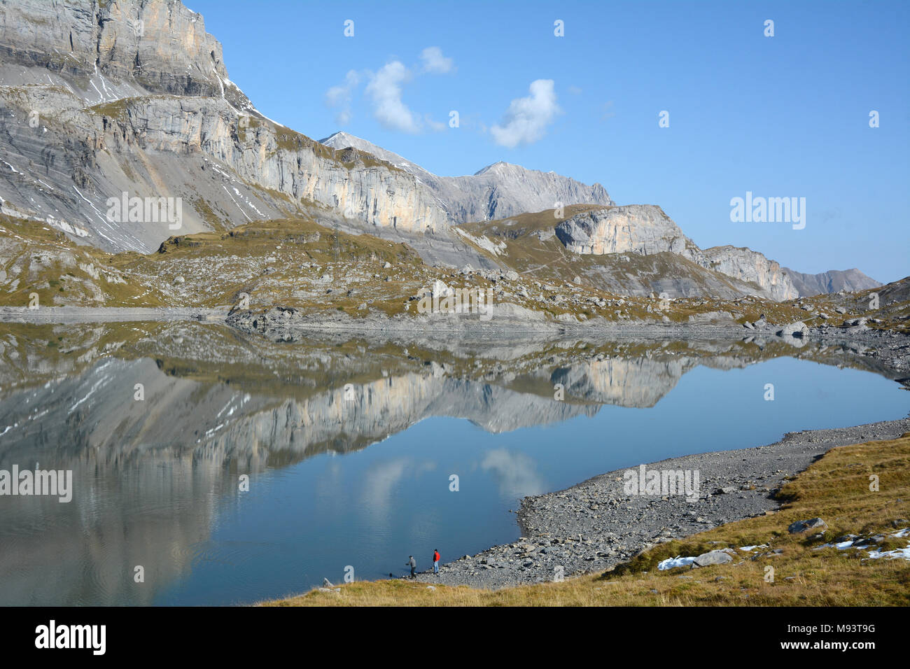 Zwei Wanderer auf einem alpinen See im Berner-oberland und Gemmipass Bereich der Berner Alpen, in der Nähe der Schweizer Ferienort Leukerbad, Schweiz. Stockfoto