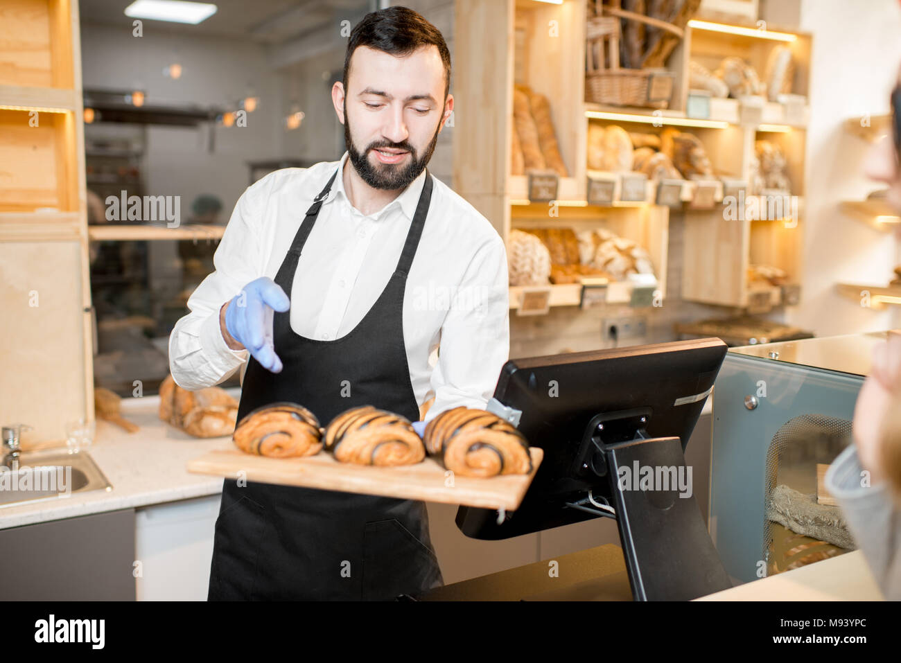 Verkäufer bietet Croissants im Store. Stockfoto