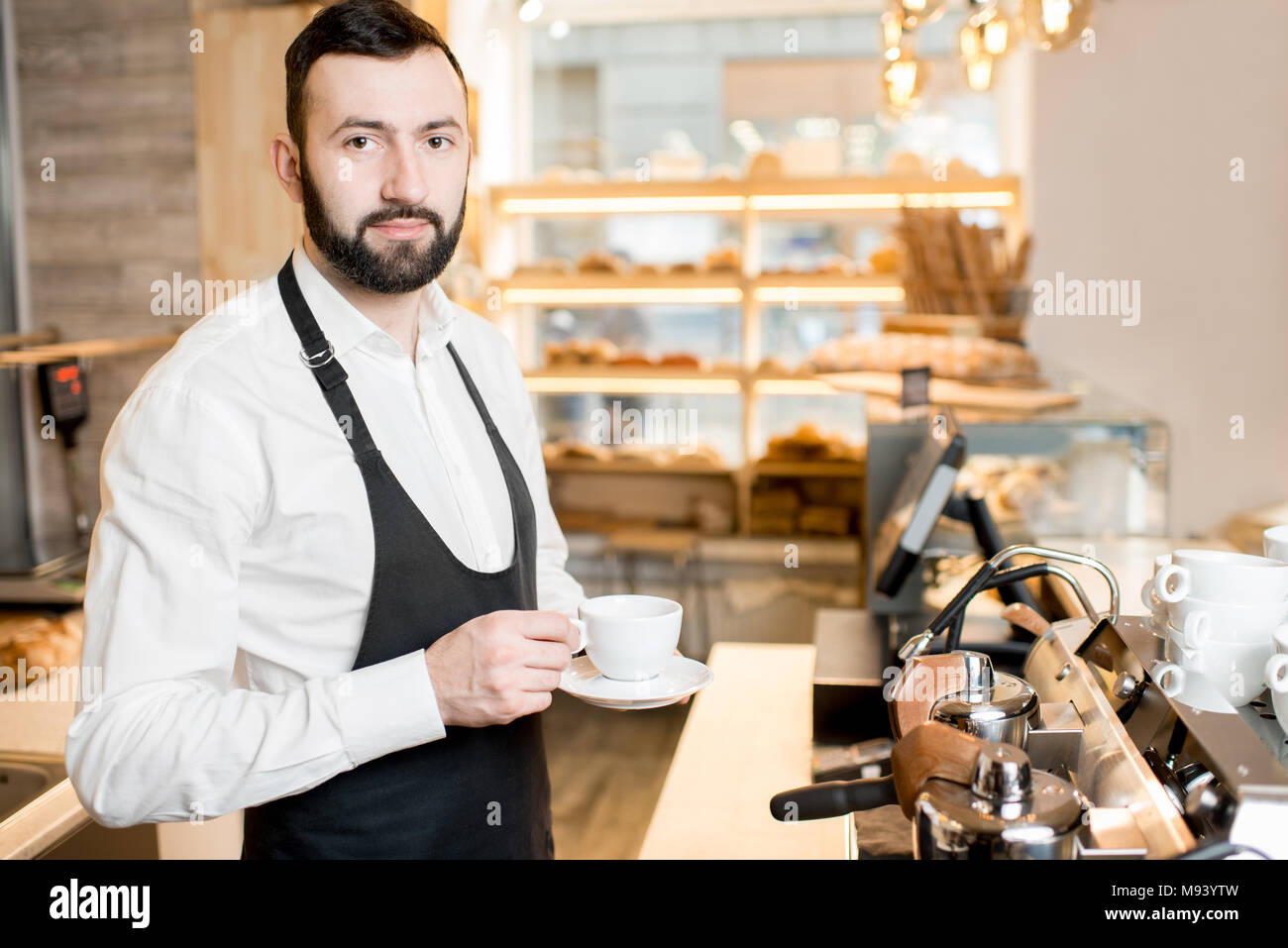 Barista mit Tasse Kaffee im Cafe Stockfoto