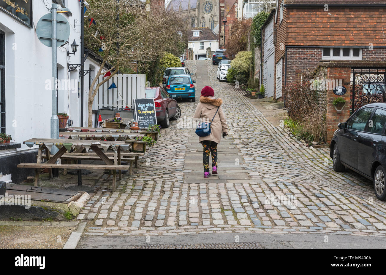 Jemand zu Fuß bis Kings Arms Hill, eine historische Straße mit Kopfsteinpflaster auf einem steilen Hügel in der historischen Marktstadt in Arundel, West Sussex, England, UK. Stockfoto
