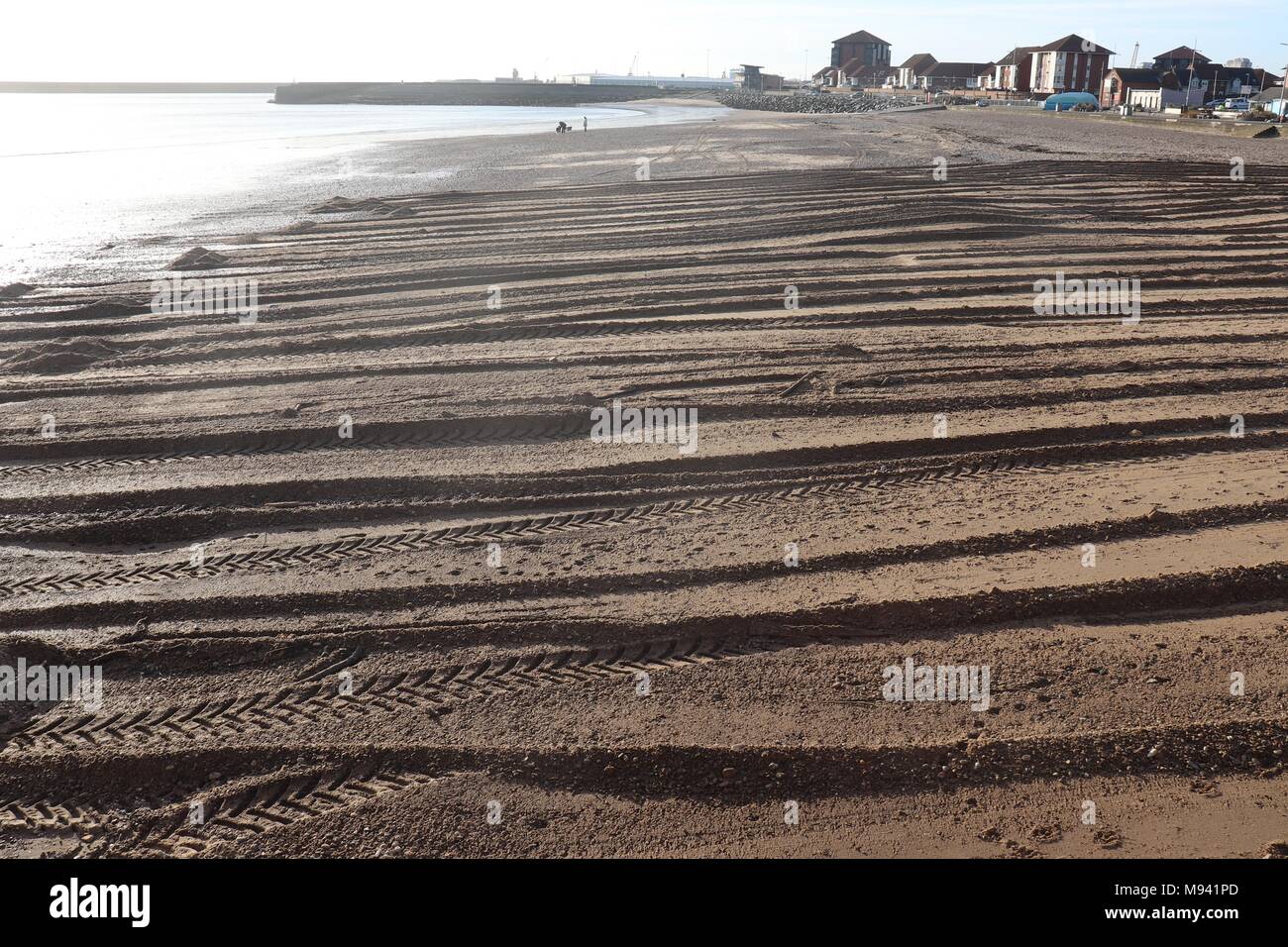 Texturen an einem Sandstrand in Roker, Wearmouth, mit einem Traktor in den frühen Morgenstunden verursacht Stockfoto