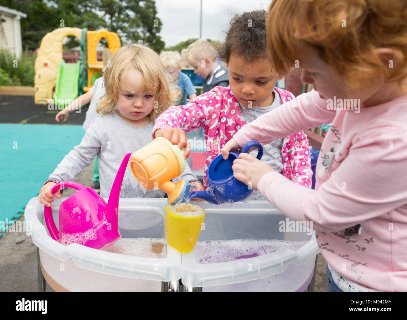 Kindergarten Kinder beim Spielen auf einem Spielplatz in Warwickshire, Großbritannien Stockfoto