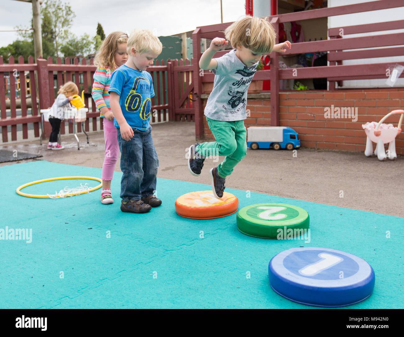Kindergarten Kinder beim Spielen auf einem Spielplatz in Warwickshire, Großbritannien Stockfoto