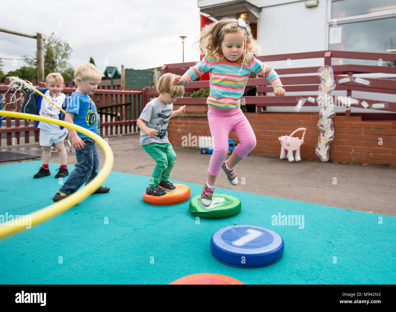 Kindergarten Kinder beim Spielen auf einem Spielplatz in Warwickshire, Großbritannien Stockfoto