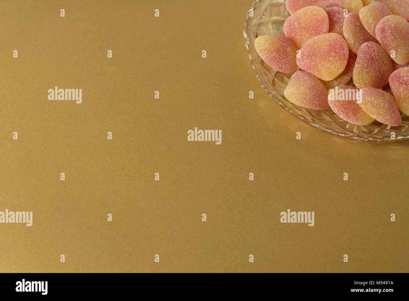 Gezuckerte gelee Süßigkeiten in Kristall Glas Teller - auf minimale gold background-design Element, kopieren Raum Stockfoto