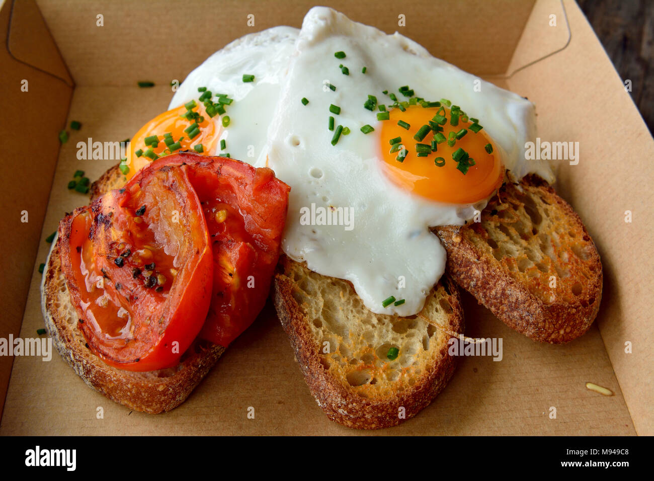 Frühstück, Toast mit gebratenen Eiern und Tomaten. Stockfoto