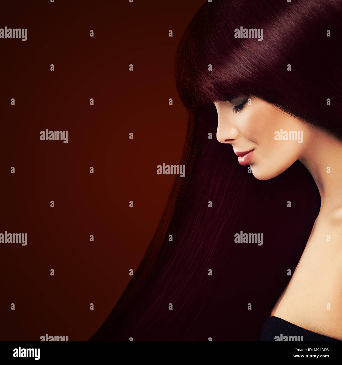 Gesundes Haar und Haare färben Konzept. Schöne Frau mit langen roten Haaren auf Hintergrund Stockfoto