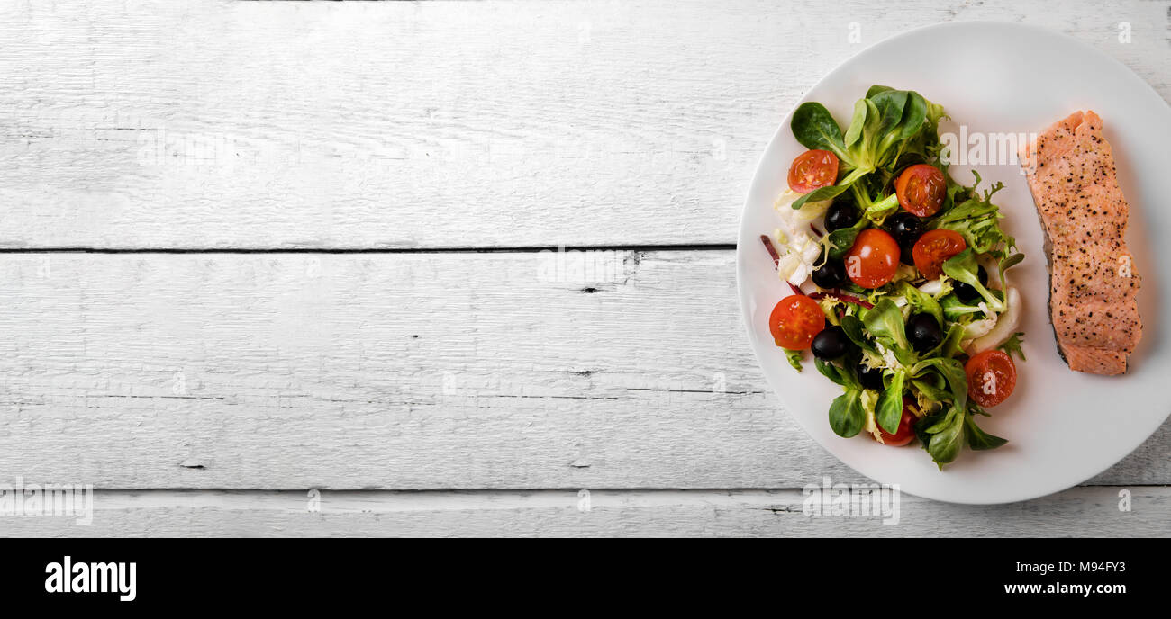 Frischer Salat mit gegrilltem Lachs filet auf weissem Holztisch. Ansicht von oben kopieren Raum Stockfoto