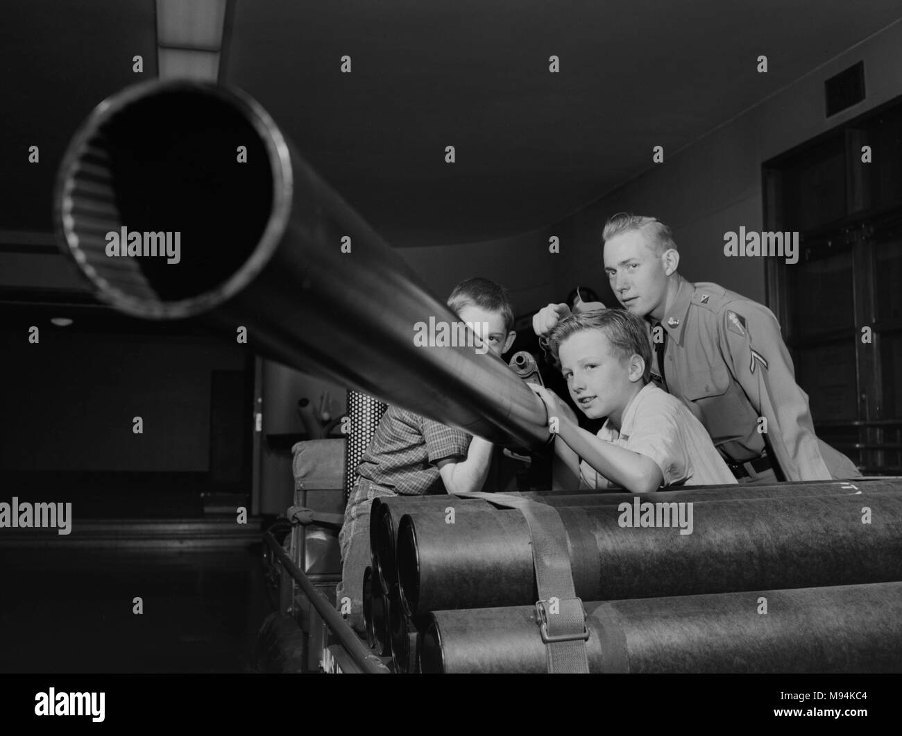Drei Jungen untersuchen eine 106 mm rückstoßfreie Gewehr auf eine Armee Ausstellung im Museum von Wissenschaft und Industrie in Chicago im Jahre 1958. Stockfoto