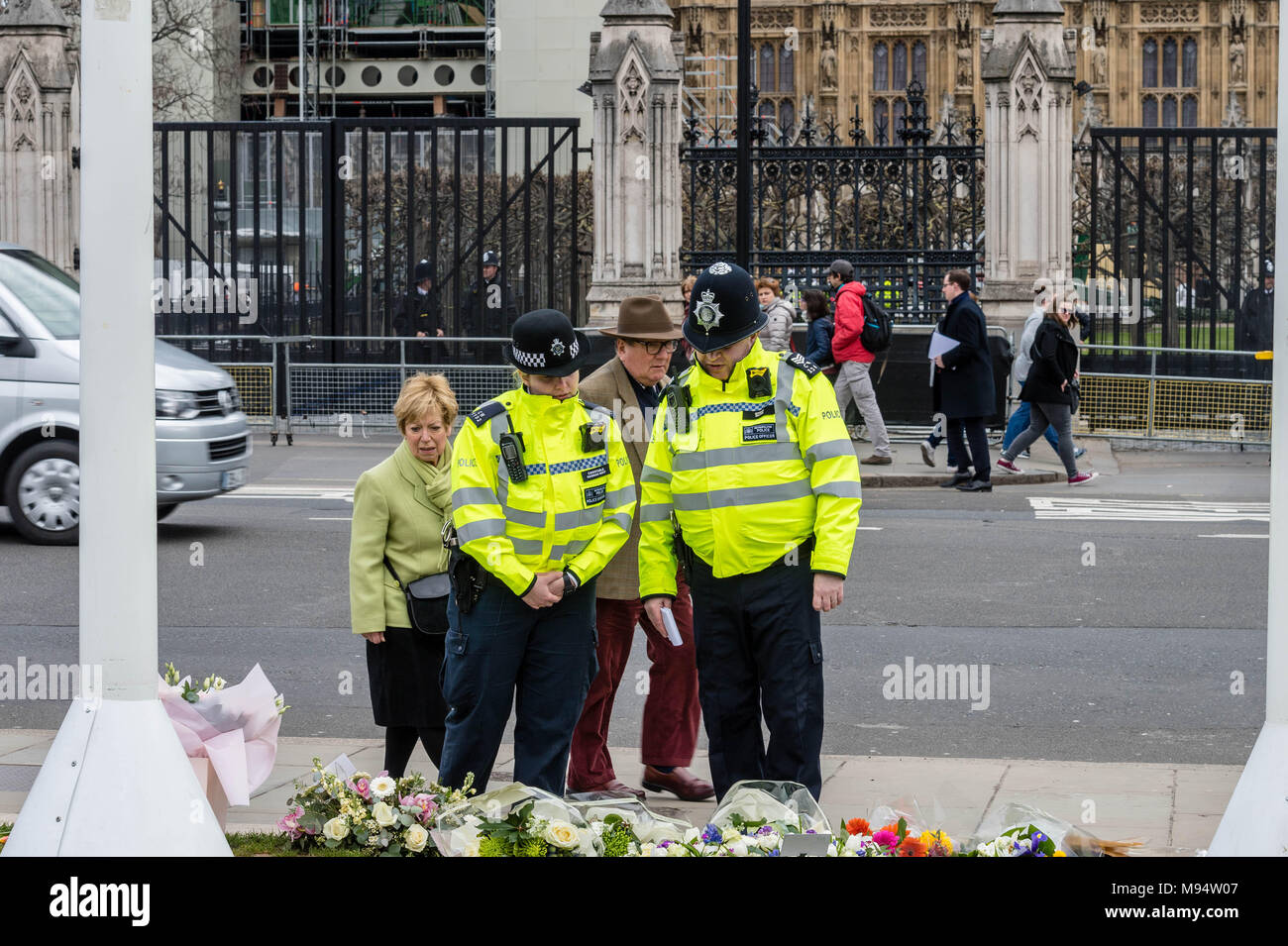 London, Großbritannien. 22. März 2018, zwei Polizisten in die Blumen am Mahnmal zum Gedenken an den ersten Jahrestag der Westminster Terroranschlag aussehen. Credit: Ian Davidson/Alamy leben Nachrichten Stockfoto