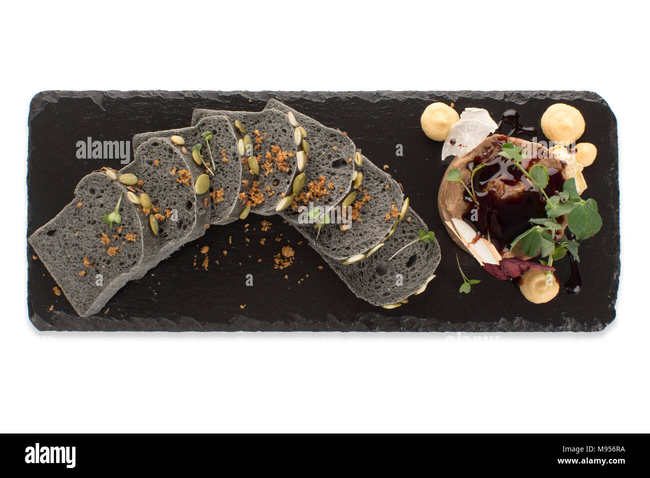 Scheiben Schwarzbrot mit Dessert auf einer Tafel Stockfoto