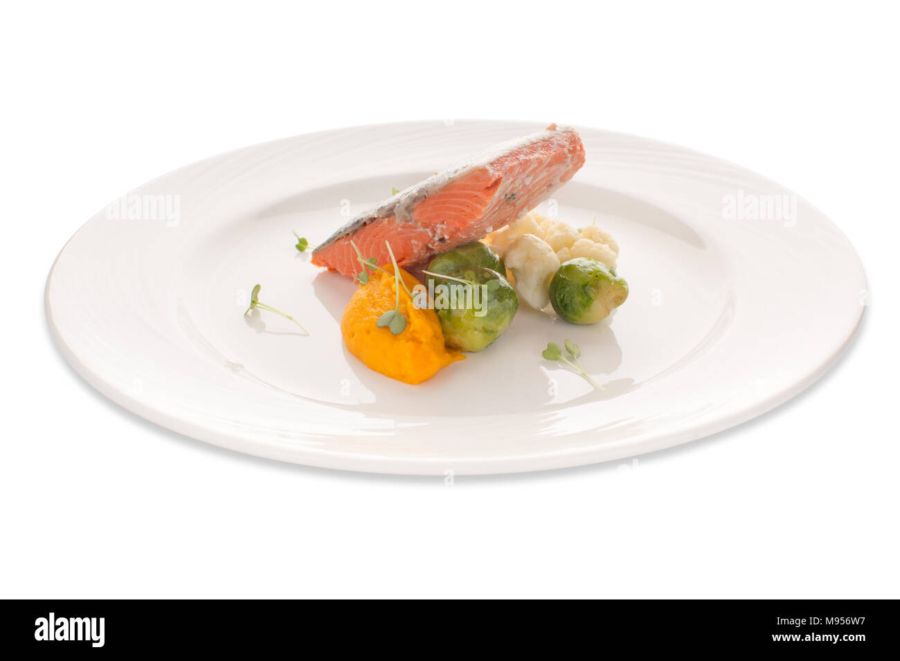 Roter Fisch mit Gemüse auf einem weißen Teller Stockfoto