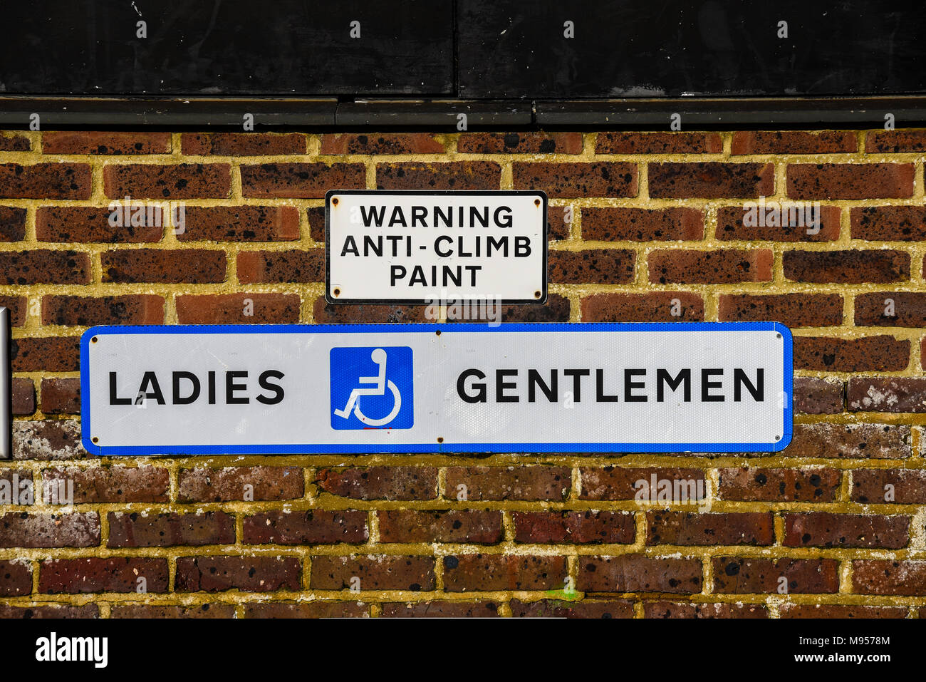 Ladys und Gentlemen Gents Toilettenschild mit Warnschildern an der Wand. Barrierefreie Toilette Stockfoto