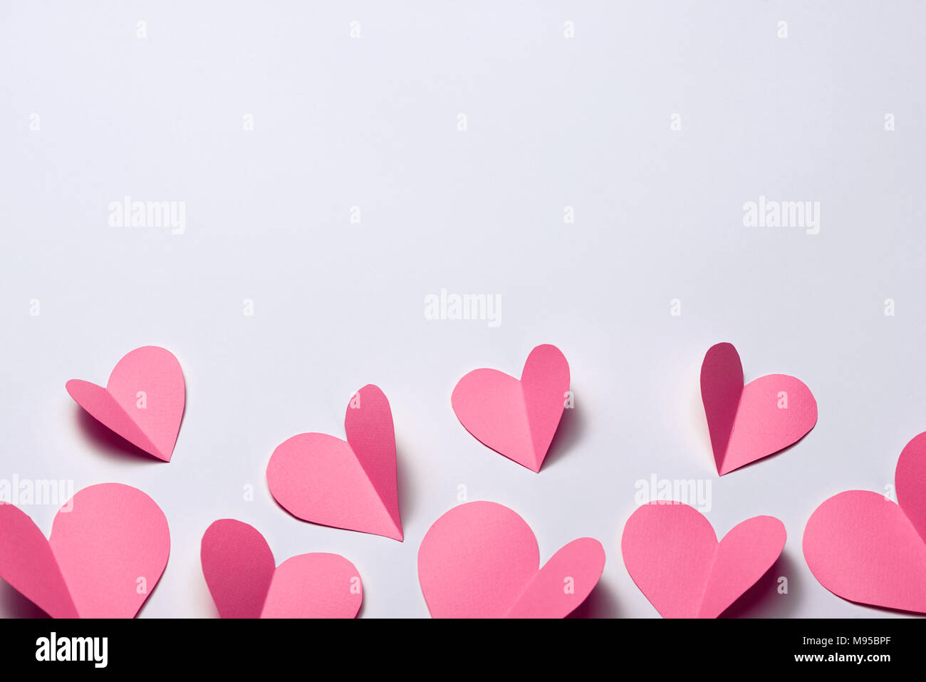 Schöne rosa Papier Herzen auf weißem Papier Hintergrund Stockfoto