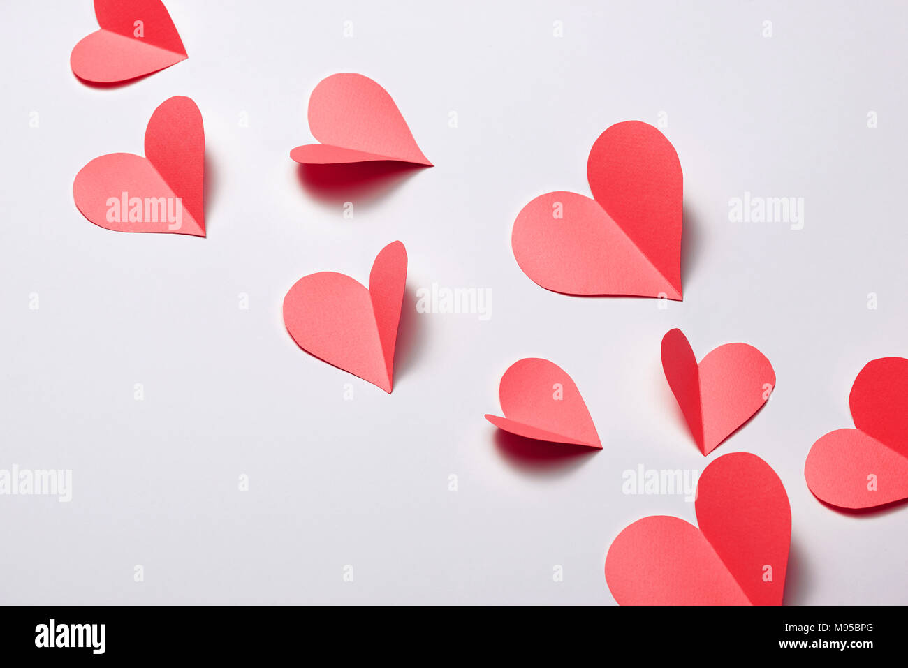 Schöne rosa Papier Herzen auf weißem Papier Hintergrund Stockfoto