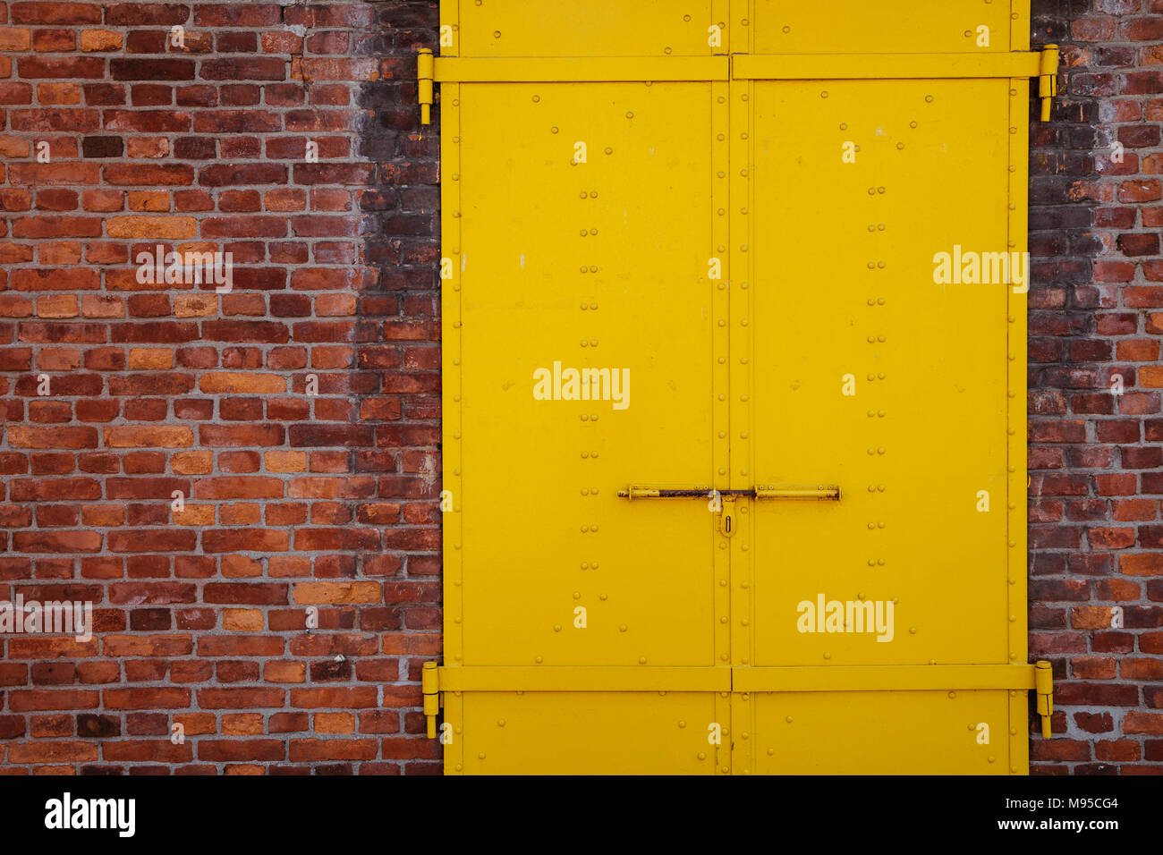 Gelb lackiertem Metall Tür und Wand Hintergrund Stockfoto