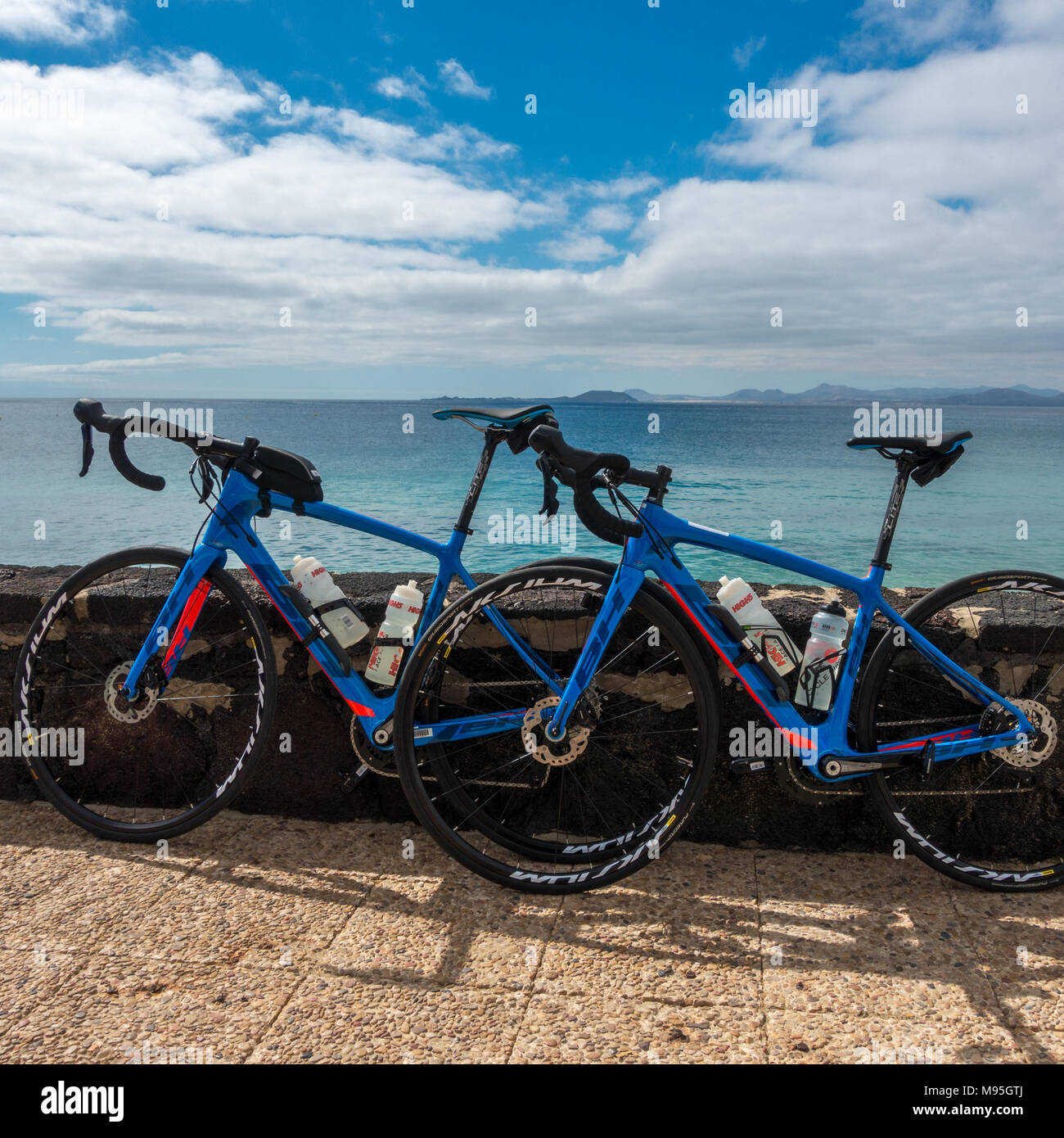 Blau und Rot BH Fahrradverleih Fahrradverleih Unternehmen - aus Lanzarote mit Blick über das Meer zu Fuerterventura Stockfoto