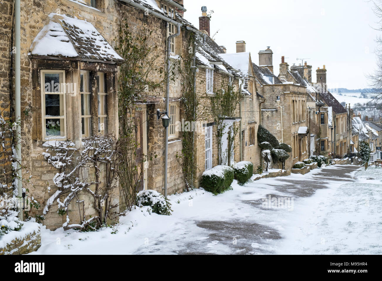 Cotswold Häuschen auf dem Hügel in Burford im Winter Schnee. Burford, Cotswolds, Oxfordshire, England Stockfoto