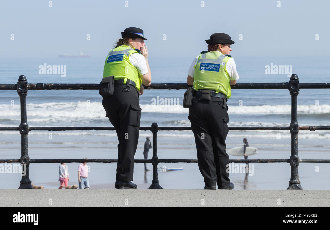 Weibliche Polizei Unterstützung der Gemeinschaft Offiziere mit Blick auf den Strand an einem sonnigen Tag Stockfoto