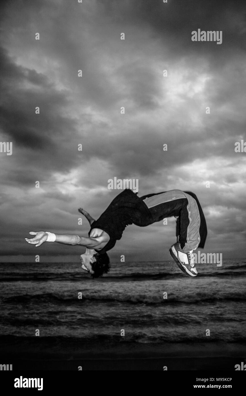 Ein monochromes, Action Shot von einem Mann auf einem Strand. Stockfoto