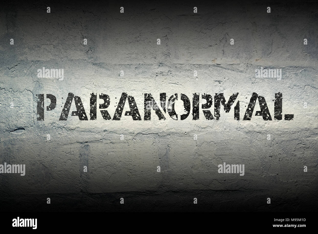 Paranormale Wort stencil Print auf der grunge White Brick Wall Stockfoto