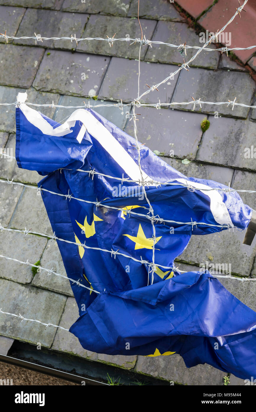 Fahne der Europäischen Union gefangen im Stacheldrahtzaun. Stockfoto