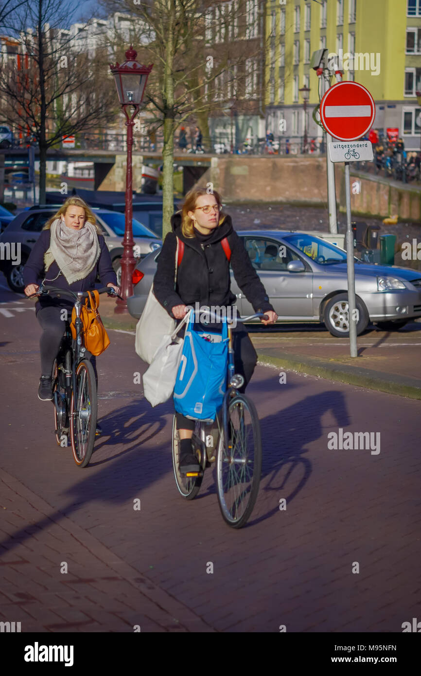 AMSTERDAM, NIEDERLANDE, MÄRZ, 10 2018: Unbekannter Menschen Reiten Fahrräder im historischen Teil in Amsterdam Stockfoto