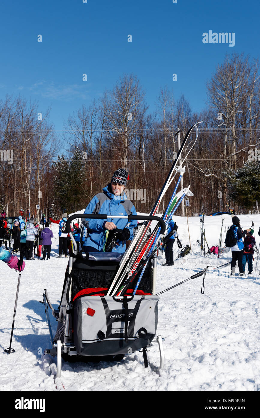 Ein Kind Träger auf Skiern mit Langlaufskiern in den Rücken, ein Skizentrum in Levis, Quebec, Kanada Stockfoto