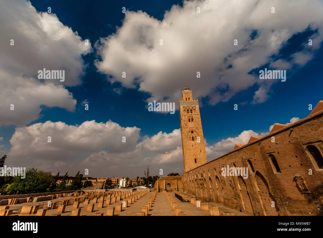 Blauer Himmel und sich schnell bewegende Wolken scud über die Koutoubia Moschee in der Mitte des Tages, Marrakesch, Marokko. Stockfoto