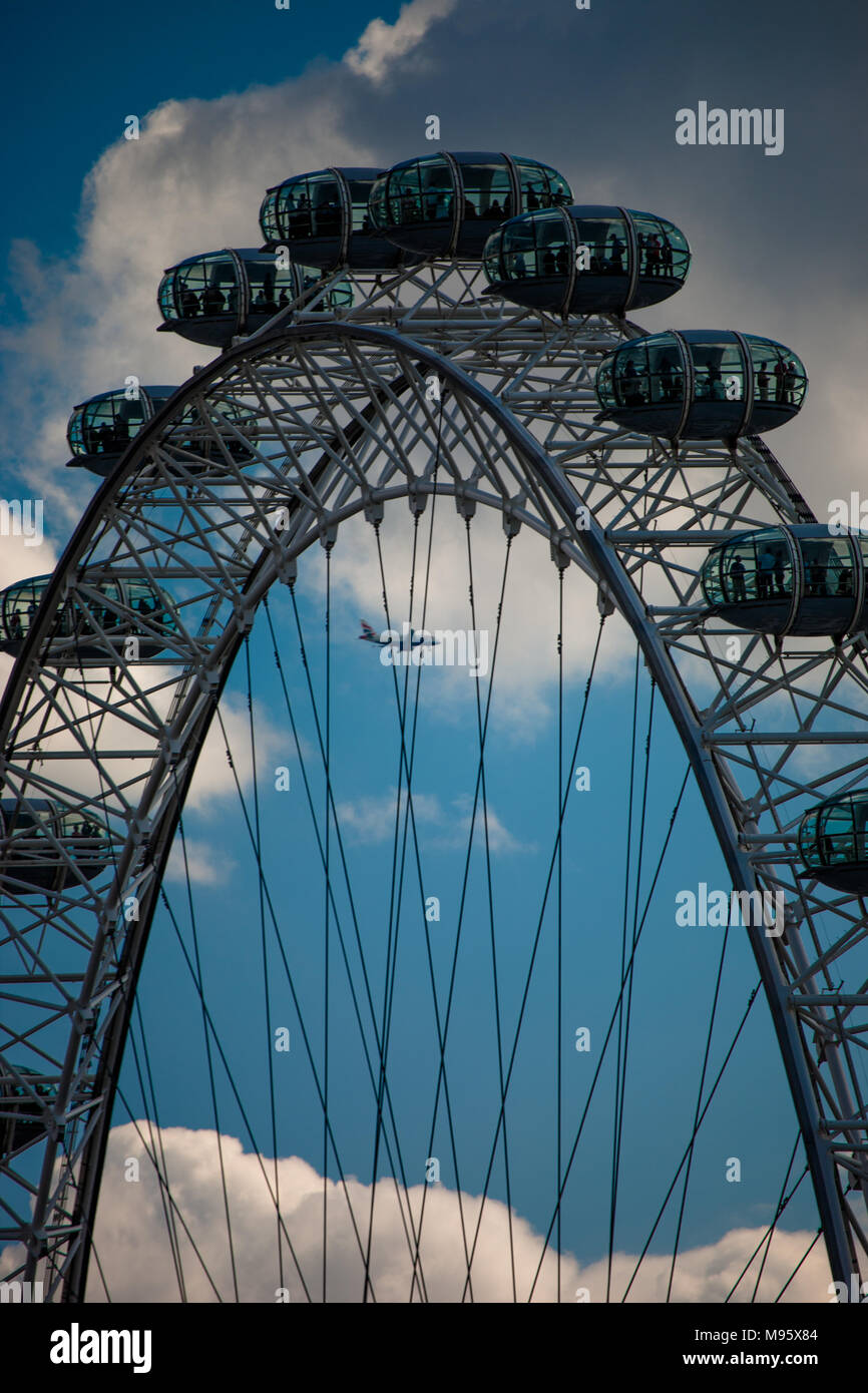 Ein Full Frame auf das London Eye als Passagier Flugzeug gesehen werden kann durch die Speichen gesehen in Land in Heathrow, London, UK. Stockfoto