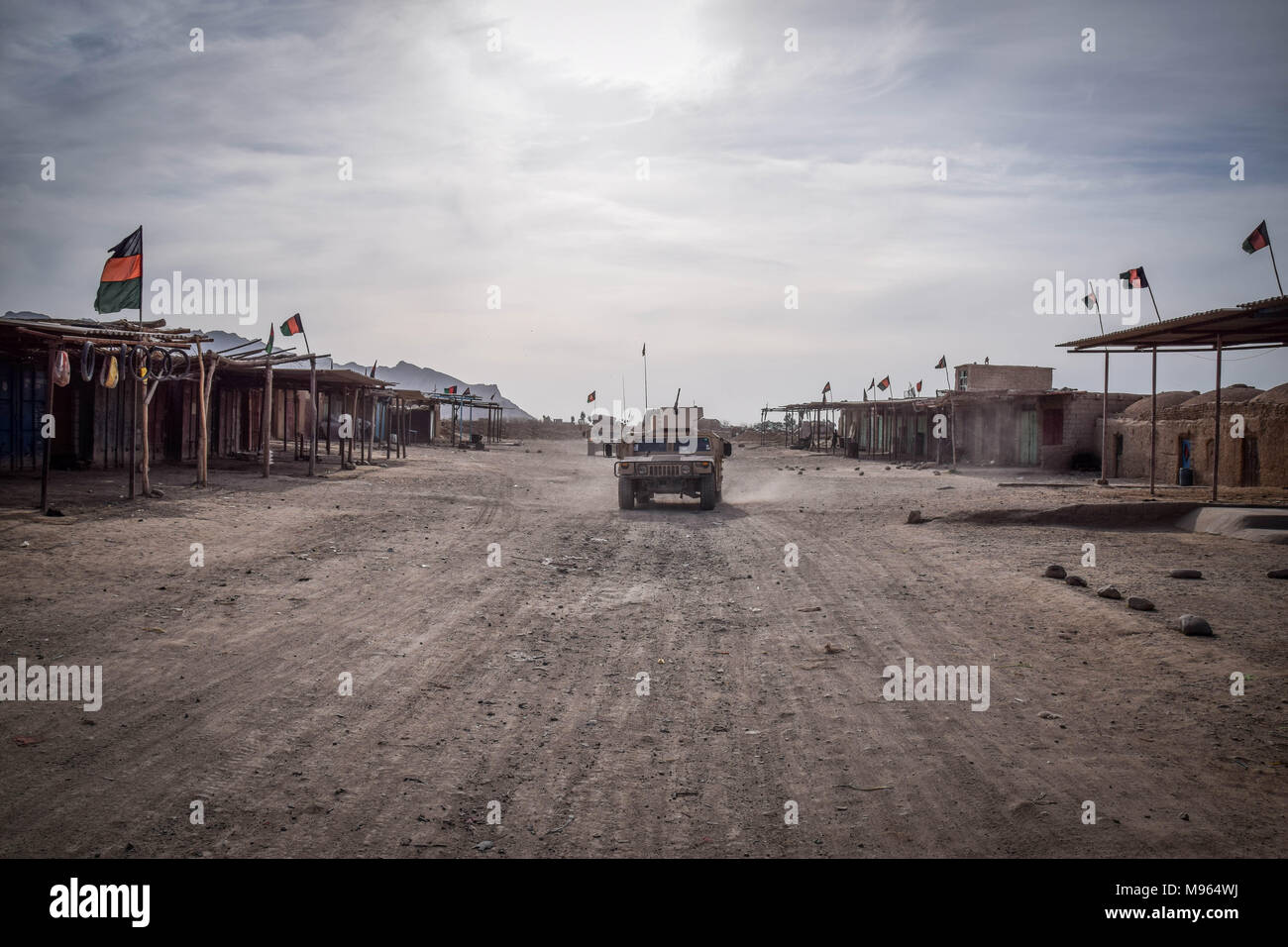 HMMWVs der Afghanischen Kommandos Fahrt durch einen leeren Teil der Farahrud Basar, Bolo Bluk Bezirk, Farah Province, Afghanistan (7. März 2018). Trotz der vielen Afghanischen Nationalen Fahnen auf den Dächern, das Gebiet ist eine Hochburg der Taliban. Später in der Nacht, die Kommandos über die gleiche Straße Rückzugsort nach einem fehlgeschlagenen Vorgangs den nahe gelegenen Dorf von Aufständischen zu wiederholen. Der afghanischen Elite Streitkräfte - die Kommandos und die besondere Kräfte sind eines der wichtigsten Elemente in der Afghanische und US-Strategie zur schleifbearbeitung Kampf gegen die Taliban und andere aufständische herum drehen. Diese pictu Stockfoto