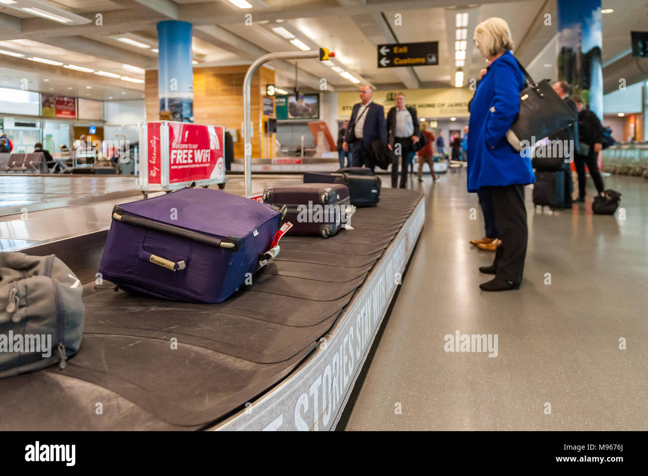 Menschen für ihr Gepäck an der Gepäckausgabe Karussell in Cork Airport, Cork, Irland wartet. Stockfoto