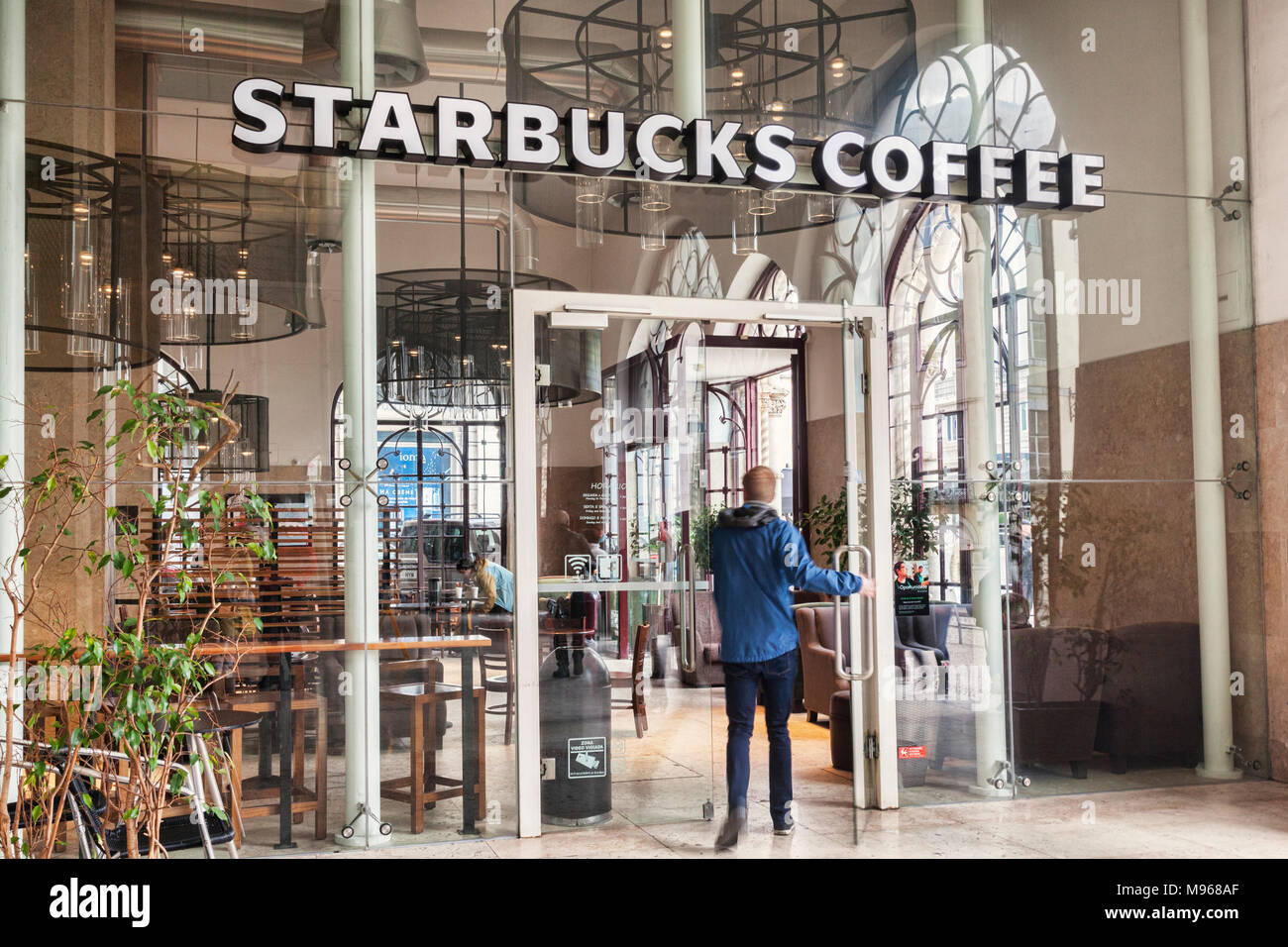 Vom 3. März 2018: Lissabon, Portugal - Junge männliche Eingabe Starbucks Copffee Shop im Bahnhof Rossio, Lissabon, Portugal. Leichte Bewegungsunschärfe am linken Bein Stockfoto