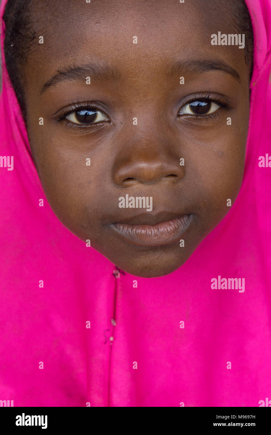 Hell in rosa Mädchen in Sansibar gekleidet Stockfoto