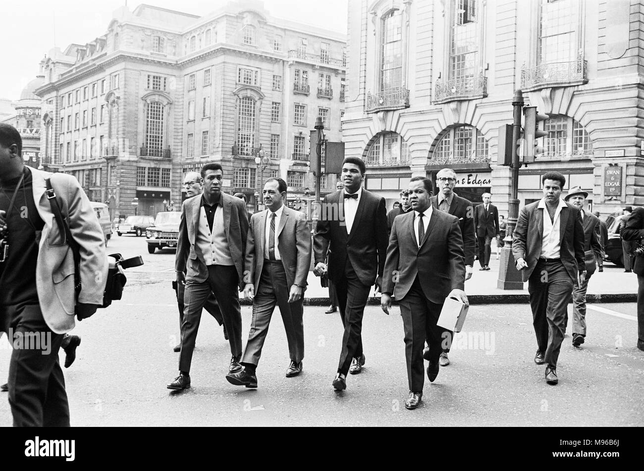Cassius Clay (Mitte) und Entourage in Piccadilly Circus auf dem Weg zu seiner Pressekonferenz für sein rematch mit Henry Cooper. 19. Mai 1966 Stockfoto