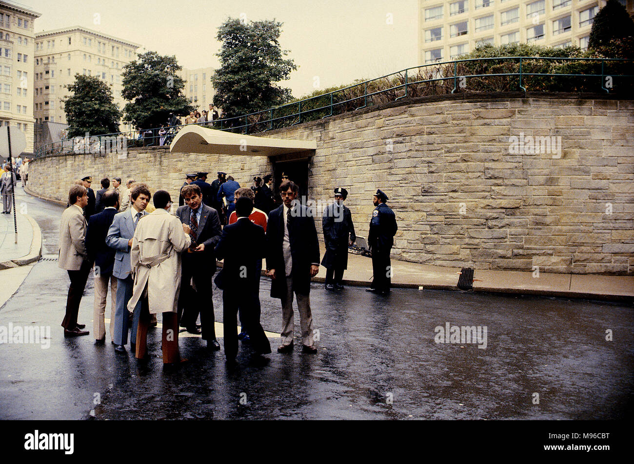 Washington, DC., USA, 30. März 1981 DC. Polizei zusammen mit FBI und Secret Service Agenten stehen außerhalb der Washington Hilton Hotel Einfahrt an der Szene, wo Präsident Ronald Reagan und 3 andere durch Assassian John Hinckley jr. Blut von James Brady's Kopf geschossen wurden, können auf dem Rost in den Bürgersteig, wo er nach der fiel gesehen werden. Credit: Mark Reinstein/MediaPunch Stockfoto