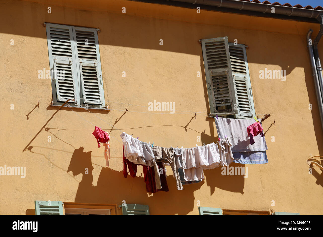 Das Trocknen von Wäsche Wäsche hängt draußen vor dem Fenster eines alten  Gebäudes in der Altstadt von Menton, Frankreich / Französische Riviera  Stockfotografie - Alamy