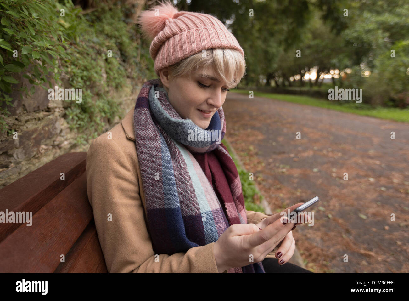 Frau in warme Kleidung mit Handy Stockfoto