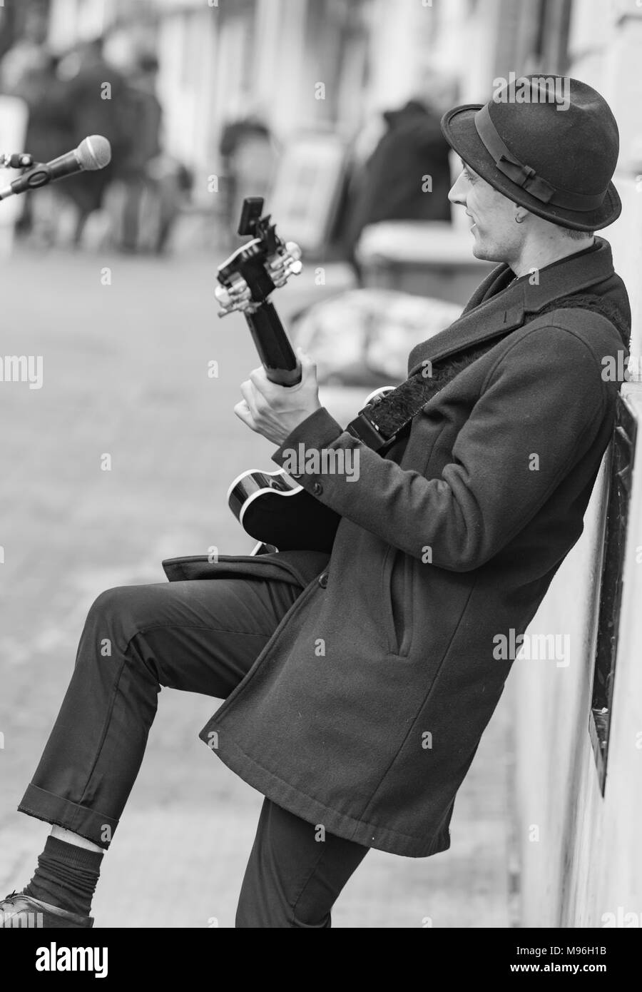 Porträt einer männlichen Straßenmusiker unterhalten der Öffentlichkeit als die Gaukler Gitarre in Brighton, East Sussex, England, Großbritannien spielt. Stockfoto